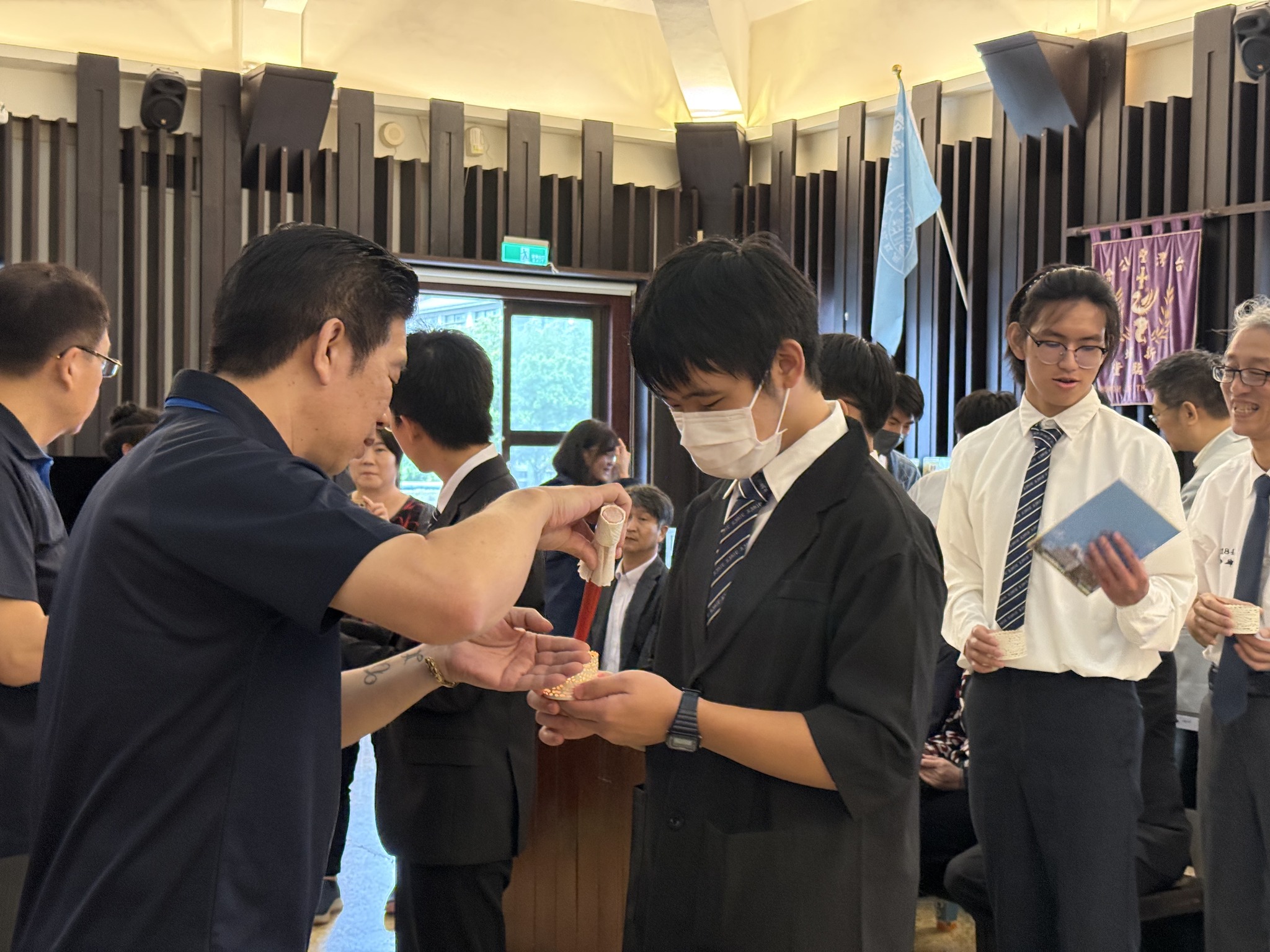 校友總會陳建宏副理事長與陳詩銘秘書長點燃成年同學手中的蠟燭，延續聖約翰傳承「光與真理」的傳統，象徵聖約翰3F精神代代相傳繼續在這一棒一棒的傳承中延續。(圖/聖約翰科技大學提供)